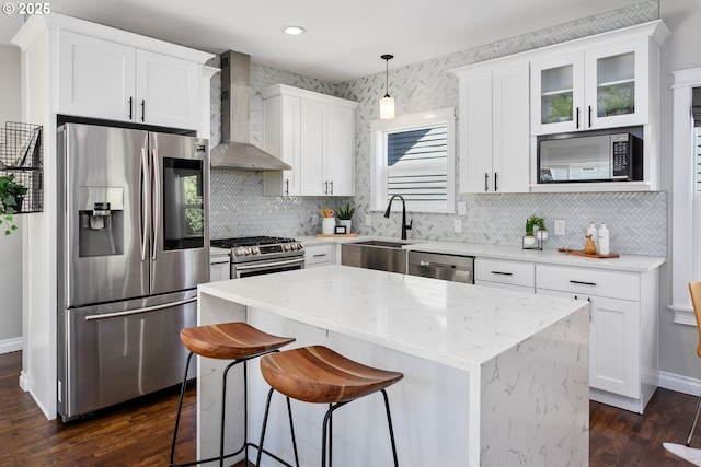 3817 NE 11th Ave, Portland, OR 97212 - kitchen with stainless steel appliances, wall chimney exhaust hood, a sink, a kitchen island, and dark wood-type flooring