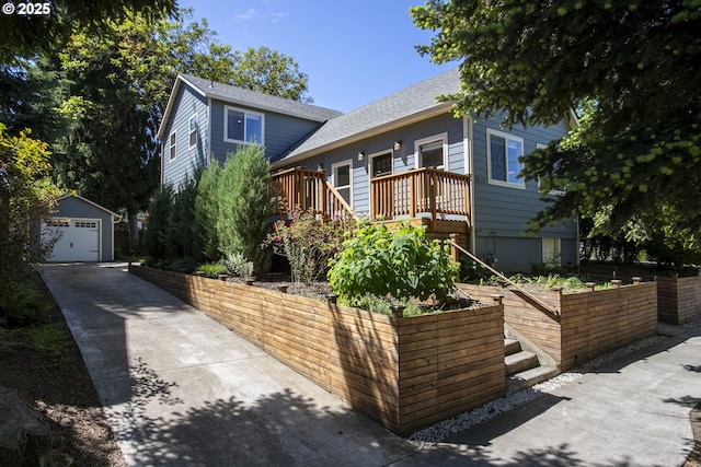 3817 NE 11th Ave, Portland, OR 97212 - view of front of property featuring a garage, an outbuilding, a shingled roof, a wooden deck, and concrete driveway