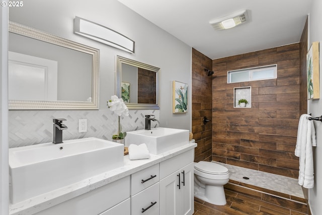 3817 NE 11th Ave, Portland, OR 97212 - bathroom with double vanity, toilet, tiled shower, and wood finished floors
