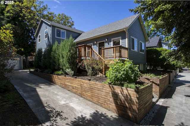 3817 NE 11th Ave, Portland, OR 97212 - view of front facade featuring roof with shingles, a deck, an outdoor structure, and driveway