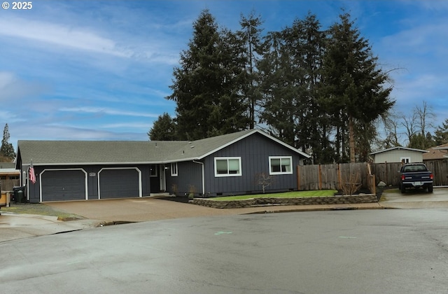 single story home with a garage, concrete driveway, and fence