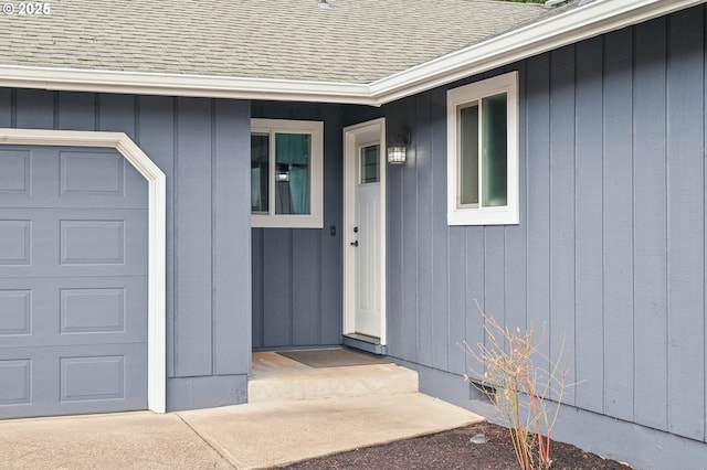 doorway to property featuring a garage and a shingled roof