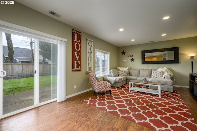 living area with recessed lighting, visible vents, baseboards, and wood finished floors