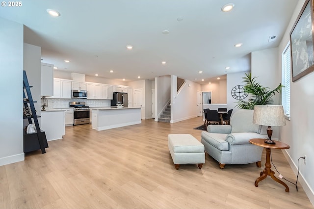 12935 SW Tabor Ter, Beaverton, OR 97007 - living room featuring stairway, light wood finished floors, and recessed lighting