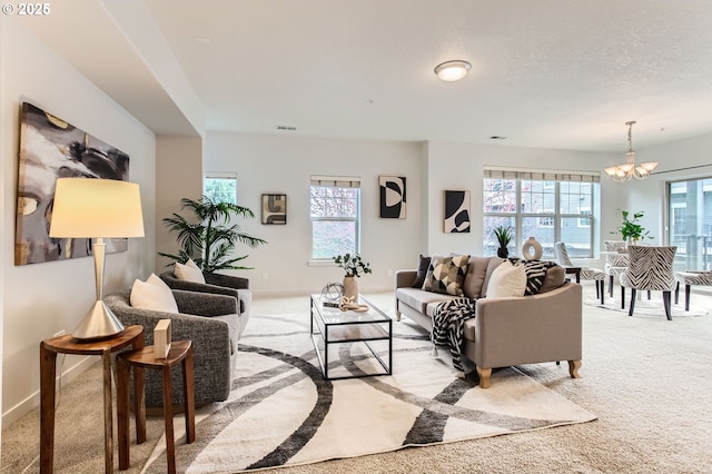 living area with baseboards, light carpet, a notable chandelier, and visible vents