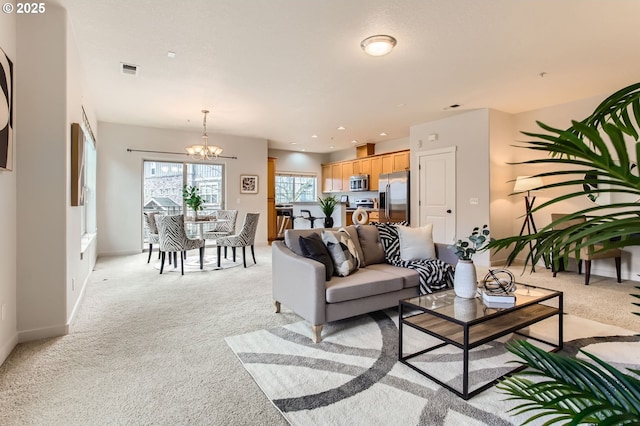 living area with visible vents, baseboards, light colored carpet, recessed lighting, and a notable chandelier