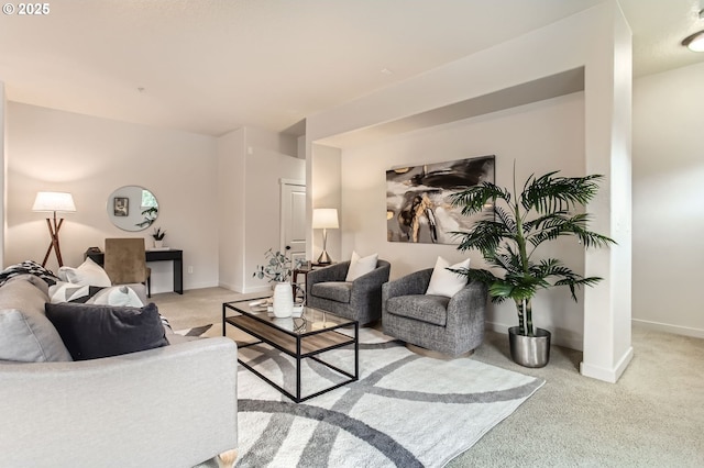 living area with light colored carpet and baseboards