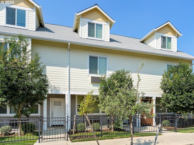 10831 E Burnside St, Portland, OR 97216 - townhome / multi-family property with a fenced front yard, a gate, and a shingled roof