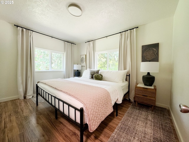 23610 E Gumjuwac Rd, Brightwood, OR 97011 - bedroom featuring multiple windows, dark wood-type flooring, a textured ceiling, and baseboards