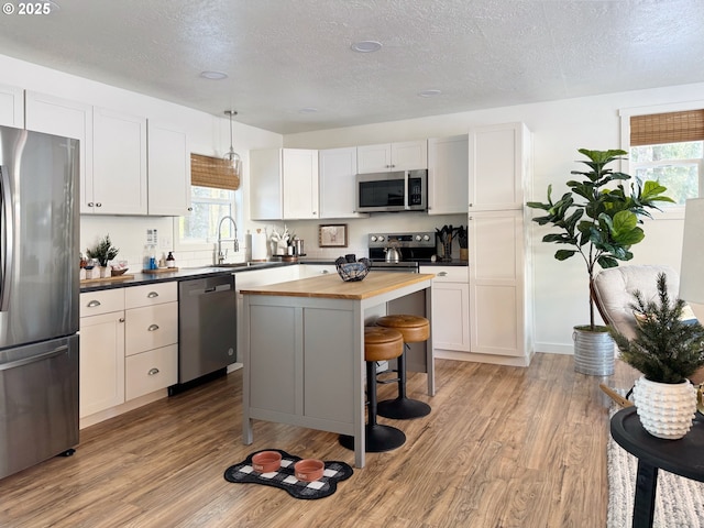 23610 E Gumjuwac Rd, Brightwood, OR 97011 - kitchen with stainless steel appliances, butcher block counters, a sink, light wood-style flooring, and a textured ceiling