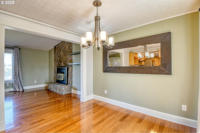 458 NW 21st St, Pendleton, OR 97801 - unfurnished living room featuring a chandelier, wood finished floors, and a fireplace