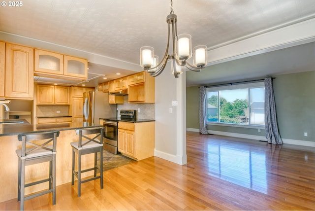 458 NW 21st St, Pendleton, OR 97801 - kitchen with stainless steel electric range, light brown cabinetry, under cabinet range hood, and an ornate ceiling