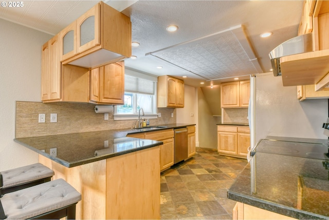 458 NW 21st St, Pendleton, OR 97801 - kitchen with dishwasher, a peninsula, range, light brown cabinetry, and backsplash