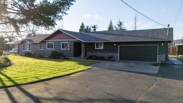 single story home featuring an attached garage, a shingled roof, concrete driveway, stone siding, and a front yard