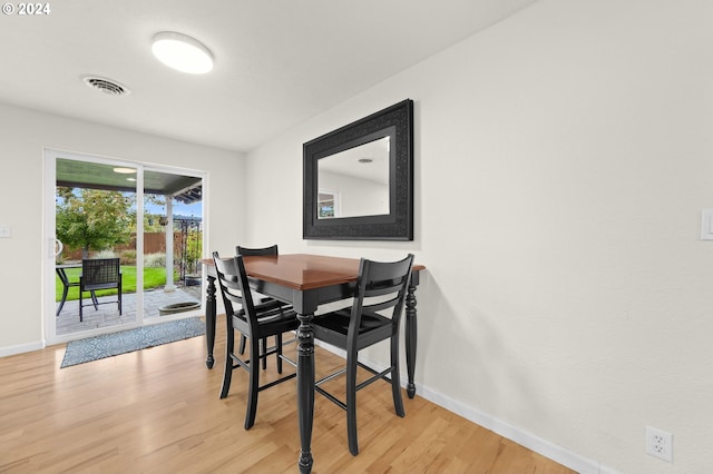 dining area featuring light wood-type flooring, baseboards, and visible vents