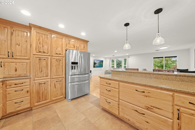 kitchen featuring light stone counters, recessed lighting, hanging light fixtures, light brown cabinetry, and stainless steel fridge with ice dispenser