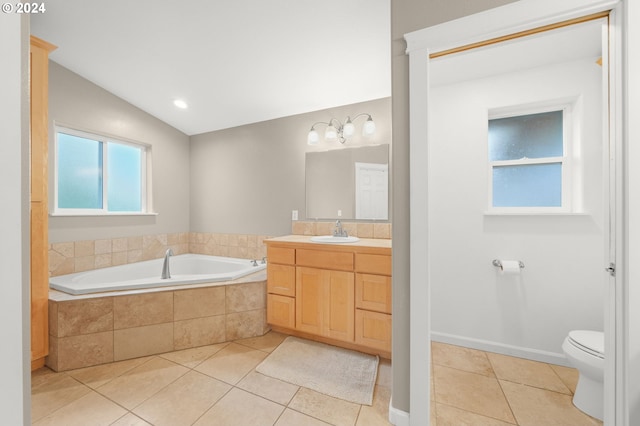 bathroom featuring lofted ceiling, toilet, vanity, tile patterned flooring, and a bath