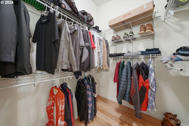 walk in closet with wood finished floors