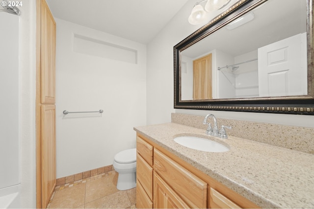 bathroom with tile patterned flooring, toilet, vanity, and baseboards