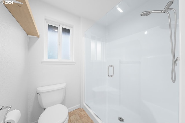 bathroom featuring a shower stall, toilet, and baseboards