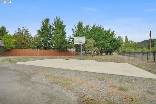 view of patio / terrace featuring fence and basketball hoop