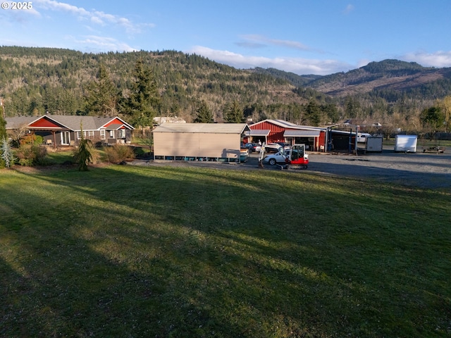 view of yard with a mountain view and a view of trees