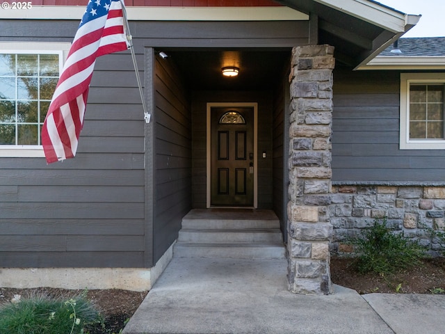 doorway to property featuring stone siding