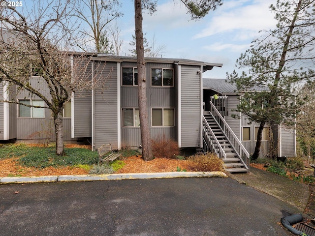 view of building exterior with uncovered parking and stairs