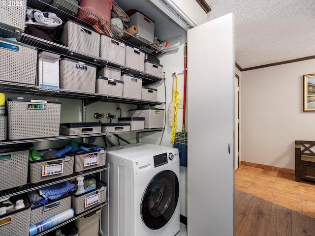 laundry area with crown molding, tile patterned flooring, baseboards, washer / dryer, and laundry area