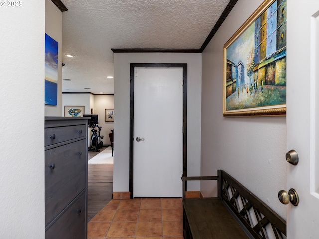 corridor with tile patterned flooring, recessed lighting, a textured ceiling, and ornamental molding