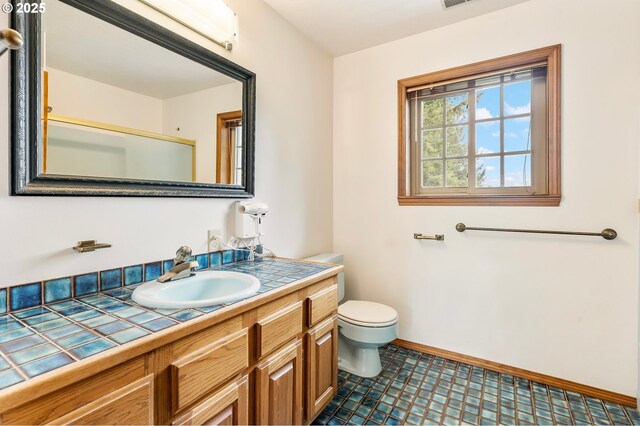 21075 NE Turner Ln, Hillsboro, OR 97123 - bathroom with vanity, toilet, baseboards, and an enclosed shower