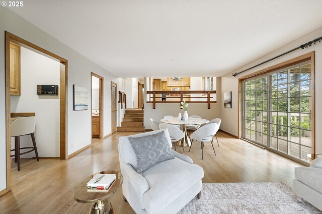 21075 NE Turner Ln, Hillsboro, OR 97123 - living area featuring light wood-style floors, stairway, and baseboards