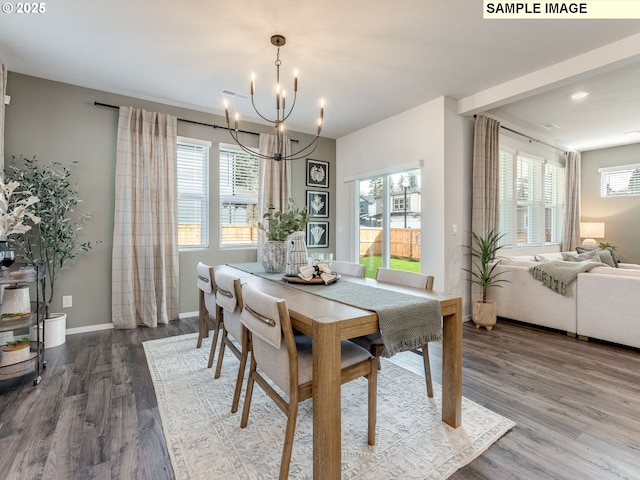 dining space with dark wood-type flooring, baseboards, and a chandelier