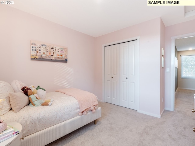 bedroom with light carpet, baseboards, and a closet