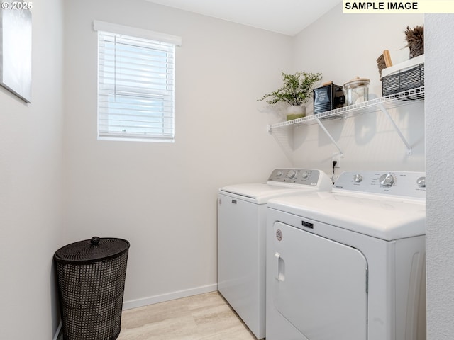 washroom featuring independent washer and dryer, light wood-style flooring, laundry area, and baseboards