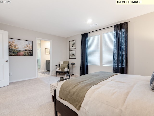 carpeted bedroom with visible vents, baseboards, and connected bathroom