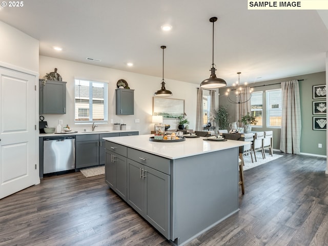 kitchen with gray cabinetry, dishwasher, light countertops, and an inviting chandelier