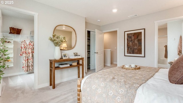 bedroom featuring baseboards, visible vents, a walk in closet, and carpet flooring