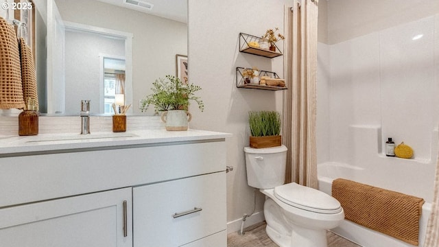 bathroom featuring baseboards, visible vents, toilet, shower / bath combo with shower curtain, and vanity