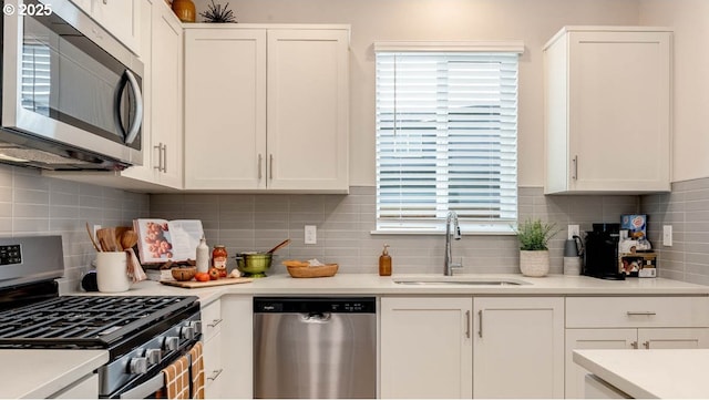 kitchen featuring white cabinetry, appliances with stainless steel finishes, light countertops, and a sink