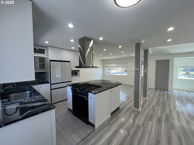 3345 SW 124th Ave, Beaverton, OR 97005 - kitchen featuring wall chimney exhaust hood, freestanding refrigerator, black range with gas stovetop, stainless steel microwave, and a kitchen island