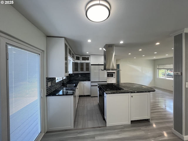 3345 SW 124th Ave, Beaverton, OR 97005 - kitchen with island exhaust hood, a kitchen island, decorative backsplash, recessed lighting, and glass insert cabinets