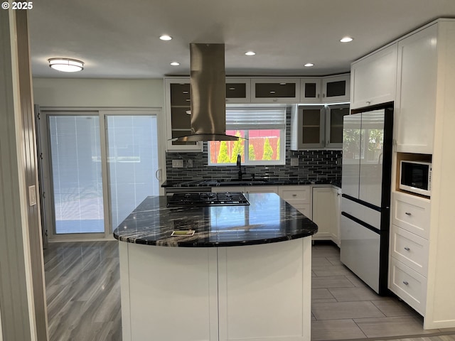 3345 SW 124th Ave, Beaverton, OR 97005 - kitchen with freestanding refrigerator, island exhaust hood, backsplash, glass insert cabinets, and recessed lighting