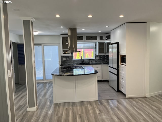 3345 SW 124th Ave, Beaverton, OR 97005 - kitchen featuring island range hood, freestanding refrigerator, light wood-type flooring, glass insert cabinets, and recessed lighting