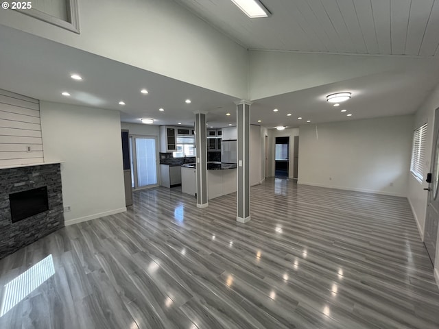 3345 SW 124th Ave, Beaverton, OR 97005 - unfurnished living room with healthy amount of natural light, lofted ceiling, recessed lighting, a stone fireplace, and light wood-style flooring