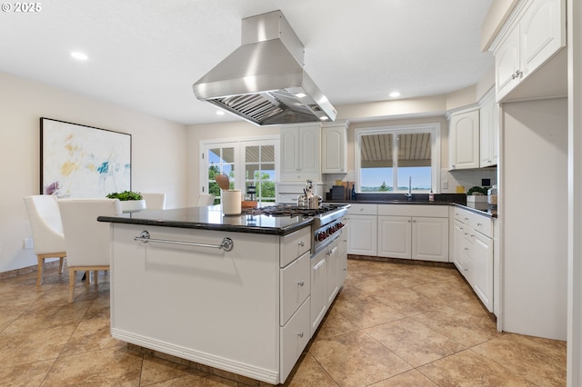 3025 SW Wallula Ave, Gresham, OR 97080 - kitchen with island range hood, dark countertops, a kitchen island, white cabinets, and healthy amount of natural light
