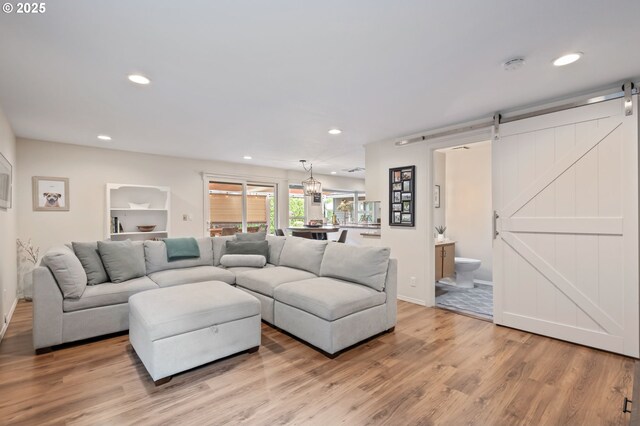 13355 SW Chimney Ridge Ct, Tigard, OR 97223 - living room with a barn door, light wood-style flooring, and recessed lighting