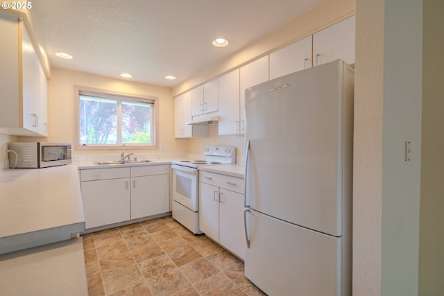 kitchen with recessed lighting, a sink, under cabinet range hood, white appliances, and light countertops