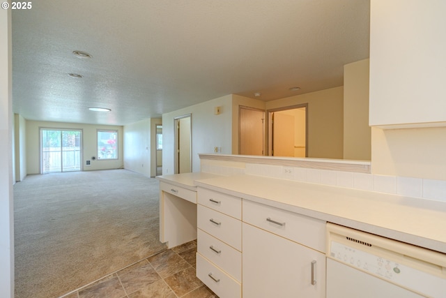 kitchen featuring light carpet, light countertops, dishwasher, white cabinets, and open floor plan