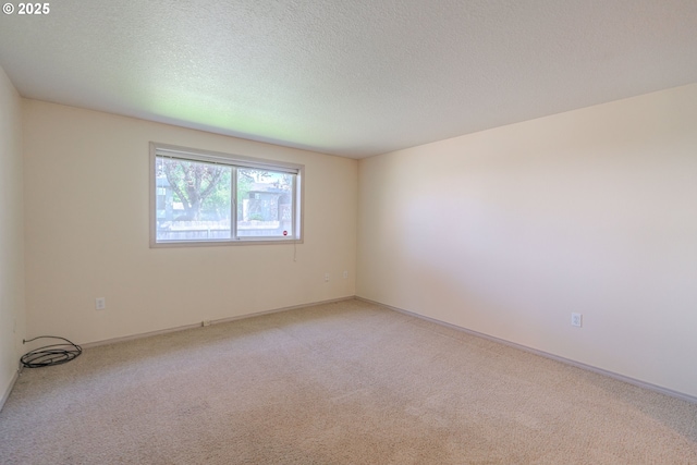 unfurnished room featuring a textured ceiling and light carpet